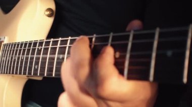 Stüdyoda beyaz gitar çalan müzisyen.