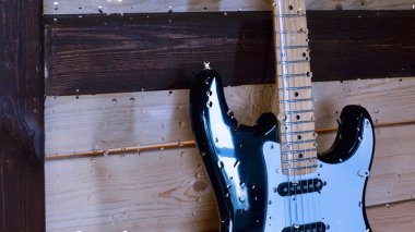 Su damlalarıyla birlikte cam arkasındaki tahtanın üzerinde elektro gitar var.