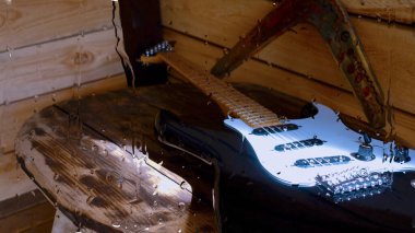 Su damlalarıyla birlikte cam arkasındaki tahtanın üzerinde elektro gitar var.