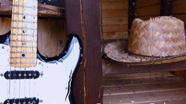 Su damlalarıyla birlikte cam arkasındaki tahtanın üzerinde elektro gitar var.