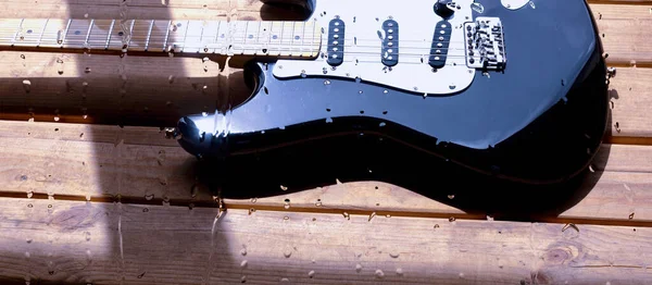 Chitarra Elettrica Sulla Tavola Legno Dietro Vetro Con Gocce Acqua — Foto Stock