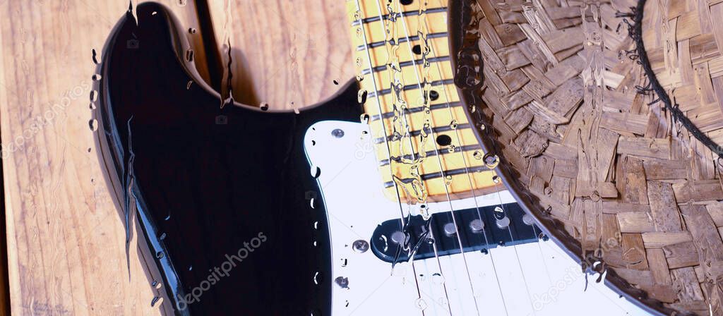 electric guitar on the wooden board behind the glass with water drops