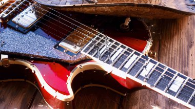 Su damlalarıyla birlikte cam arkasındaki tahtanın üzerinde elektro gitar var.