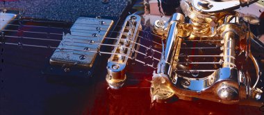 Su damlalarıyla birlikte cam arkasındaki tahtanın üzerinde elektro gitar var.