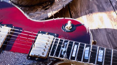 Su damlalarıyla birlikte cam arkasındaki tahtanın üzerinde elektro gitar var.