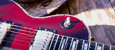 Su damlalarıyla birlikte cam arkasındaki tahtanın üzerinde elektro gitar var.