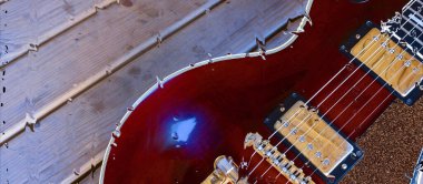 Su damlalarıyla birlikte cam arkasındaki tahtanın üzerinde elektro gitar var.