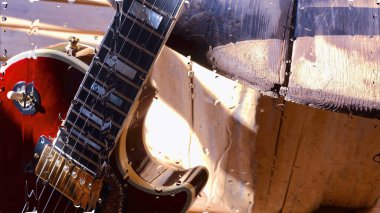 Su damlalarıyla birlikte cam arkasındaki tahtanın üzerinde elektro gitar var.