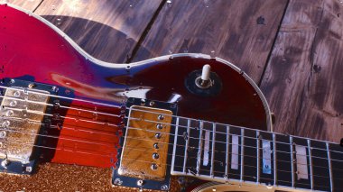 Su damlalarıyla birlikte cam arkasındaki tahtanın üzerinde elektro gitar var.