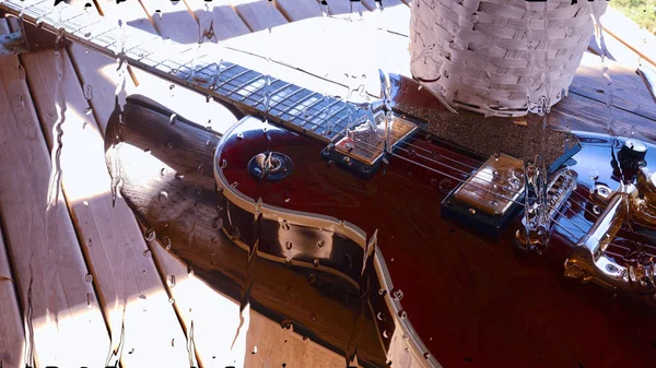 玻璃后面的木板上有电吉他 上面有水滴 — 图库照片