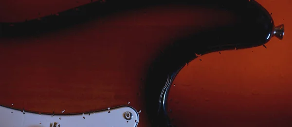 水滴付きのガラスの後ろのギターヘッドストック 背景色 スペースのコピー — ストック写真