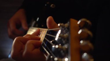 Mikrofonun yanındaki stüdyoda gitar çalan müzisyen.