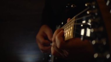 Mikrofonun yanındaki stüdyoda gitar çalan müzisyen. Yavaş çekim