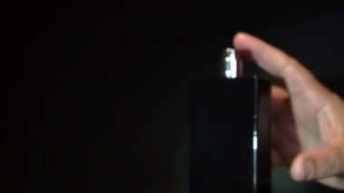 Püskürt. Siyah şişe ve el. koyu arkaplan