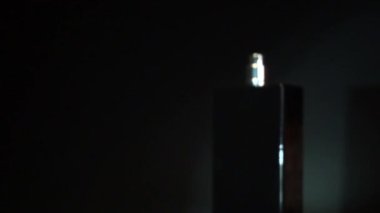 Püskürt. Siyah şişe ve el. koyu arkaplan