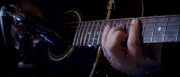 音乐家在玻璃杯后面麦克风旁边的录音室里用水滴弹吉他 — 图库照片