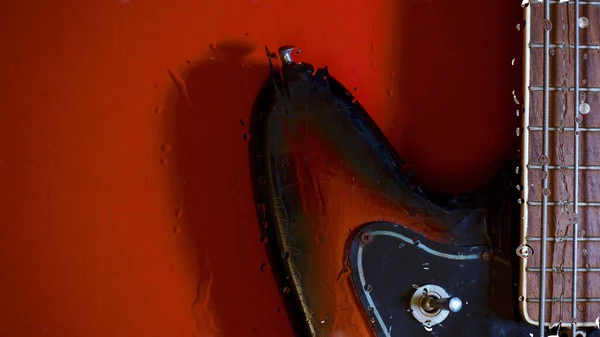グラスの後ろに水が落ちるベースギター — ストック写真