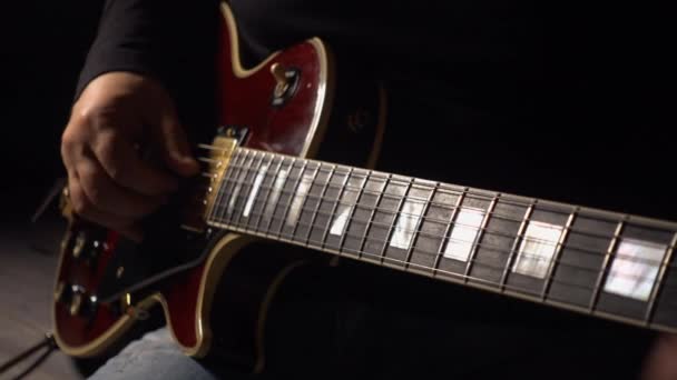 ミュージシャンはスタジオでギターを演奏する 閉鎖だ 暗い背景 — ストック動画