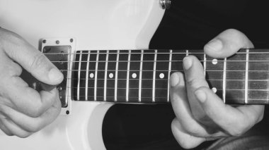 Müzisyen yakın plan gitar çalıyor. Siyah ve beyaz