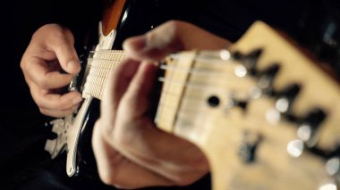 Müzisyen stüdyoda gitar çalıyor. Yakın çekim