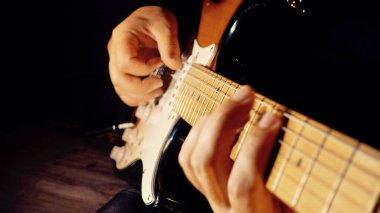 Müzisyen stüdyoda gitar çalıyor. Yakın çekim