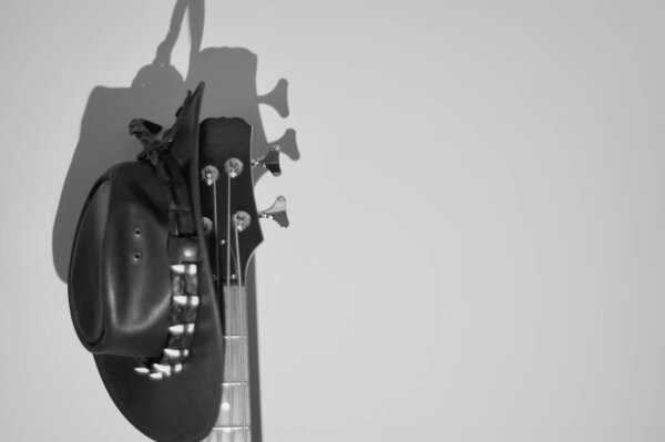 Bass guitar headstock and cowboy hat . black and white