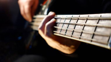 Müzisyen stüdyoda bas gitar çalıyor. 
