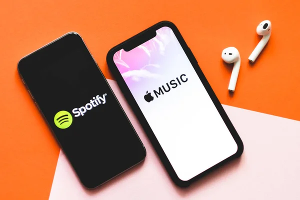 Manos sosteniendo iPhone X con captura de pantalla de la aplicación de música de Apple y Spotify . — Foto de Stock