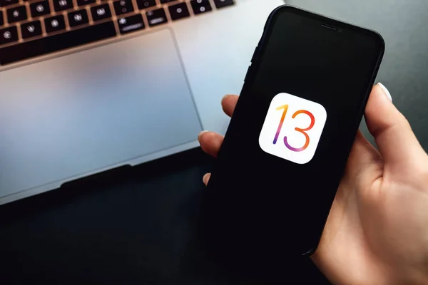 IPhone y MacBook con el logotipo de iOS 13 en la pantalla . —  Fotos de Stock