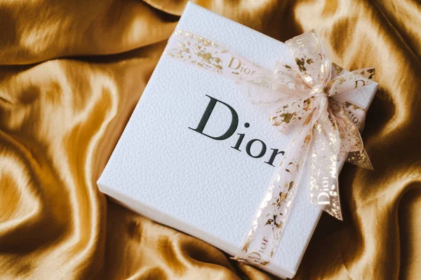 Caja de regalo de dior con maquillaje en una tela dorada . —  Fotos de Stock