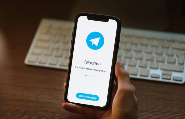 Женщина использует приложение Telegram, логотип Telegram на экране  . — стоковое фото