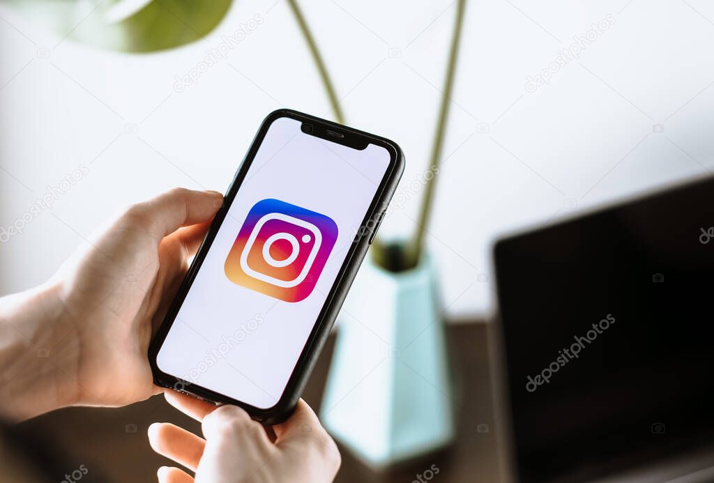 Instagram app logo on the smartphone screen. Female use instagram app. High quality photo.