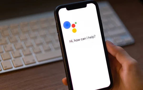 Kobieta korzystać z aplikacji Google Assistant na iPhone. — Zdjęcie stockowe