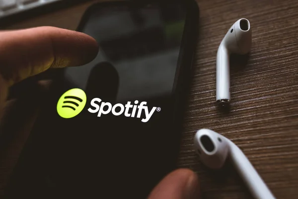 IPhone X και AirPods με στιγμιότυπο οθόνης της εφαρμογής Spotify . — Φωτογραφία Αρχείου