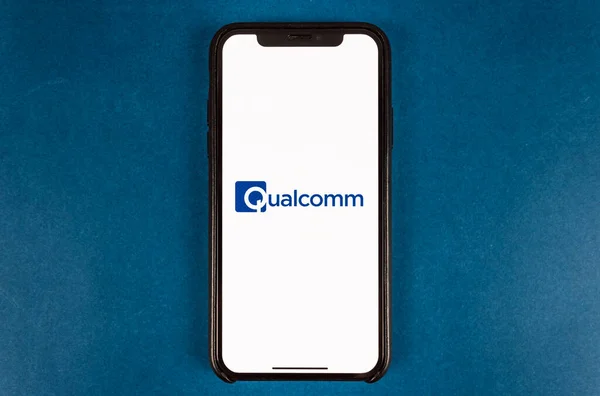 Hand holds smartphone with qualcomm logo. — Stock Photo, Image