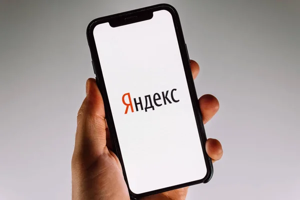 Рука держит смартфон с логотипом Яндекса на экране . — стоковое фото