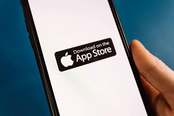 Smartphone in de hand met downloaden op het pictogram van de app store. — Stockfoto