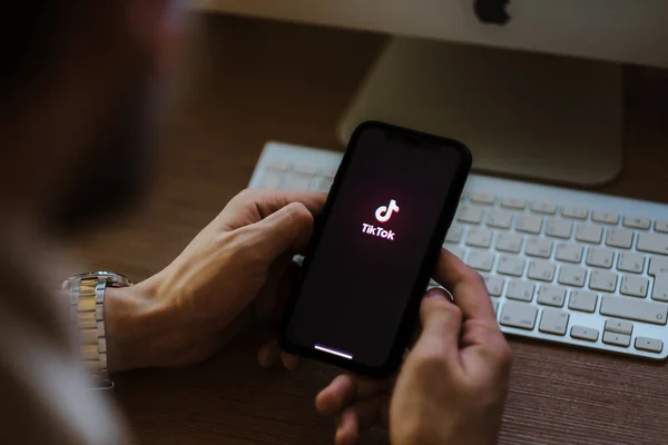 Hombre utilizar la aplicación Tik Tok, logotipo de TikTok en la pantalla  . —  Fotos de Stock