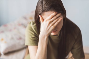 Alnına dokunan yorgun genç bir kadın baş ağrısı ya da depresyon geçiriyor..