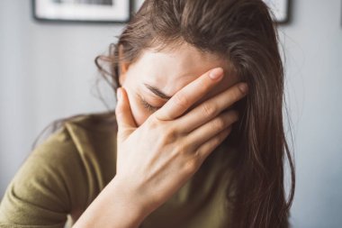 Alnına dokunan yorgun genç bir kadın baş ağrısı ya da depresyon geçiriyor..