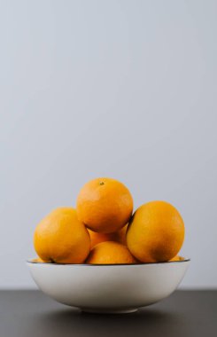 Beyaz kasede parlak, sulu bir portakal.