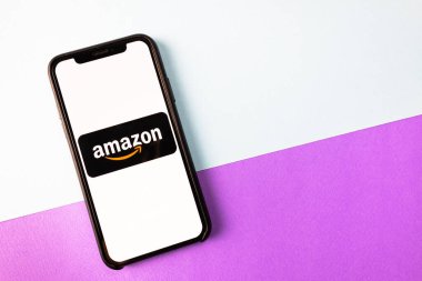  Parlak arkaplanda akıllı telefon ekranında Amazon mağaza logosu.