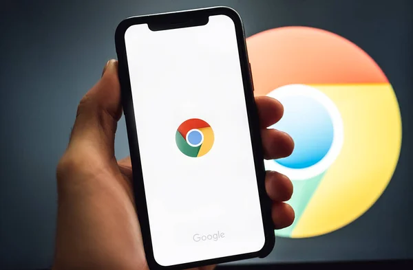 Mão segurando o iPhone com o aplicativo do navegador Google Chrome na tela — Fotografia de Stock