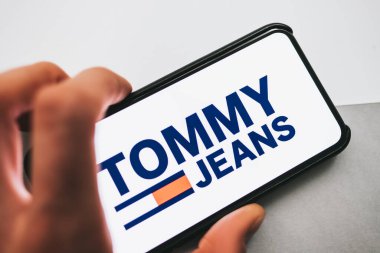 Ekranda Tommy Jeans logosu olan iPhone.