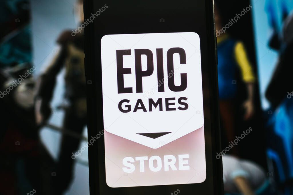 Hand holding smartphone with epic games store logo on the screen. High quality photo