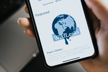  Eller ekranda Wikileaks logo sitesi olan iPhone X 'i tutuyor.