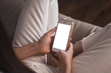 Beyaz ekranlı akıllı telefon kullanan bir kadın..