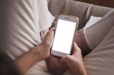 Beyaz ekranlı akıllı telefon kullanan bir kadın..