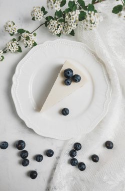 Beyaz tabakta yaban mersinli cheesecake.