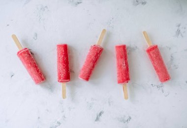 Beyaz arka planda pembe meyveli buzlu şerbet. Dondurma çubuğu. Kapatın. Yüksek kalite fotoğraf